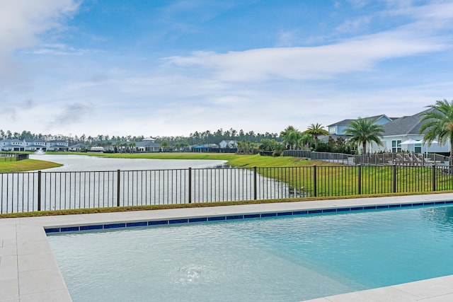 view of pool featuring a lawn and a water view