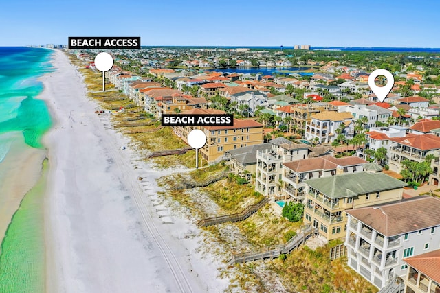 birds eye view of property featuring a water view and a beach view