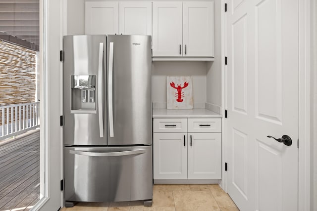 kitchen with stainless steel fridge and white cabinetry