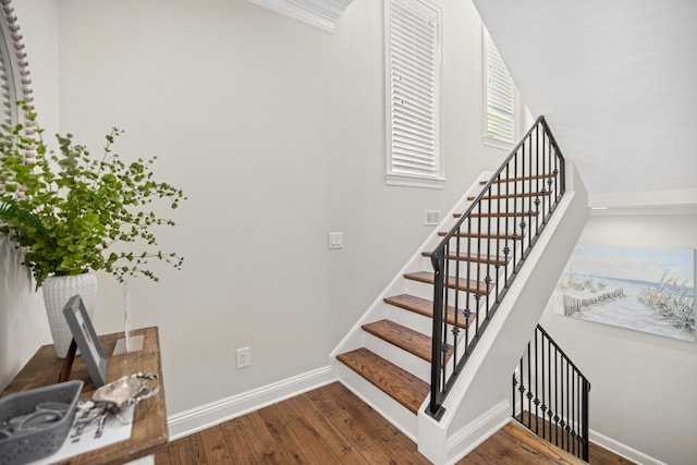 stairs featuring hardwood / wood-style flooring and crown molding