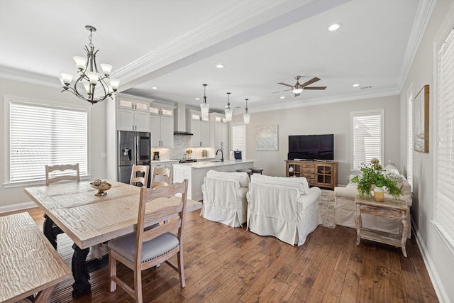 dining space featuring crown molding, dark hardwood / wood-style flooring, ceiling fan with notable chandelier, and sink