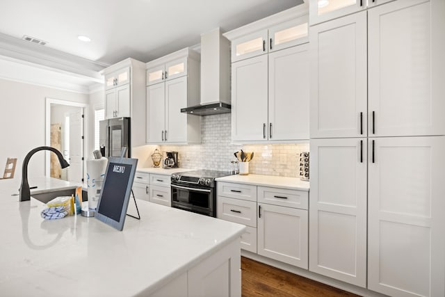 kitchen featuring light stone countertops, appliances with stainless steel finishes, dark hardwood / wood-style flooring, wall chimney exhaust hood, and white cabinetry