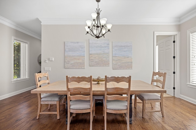 dining area with hardwood / wood-style floors, a notable chandelier, and crown molding