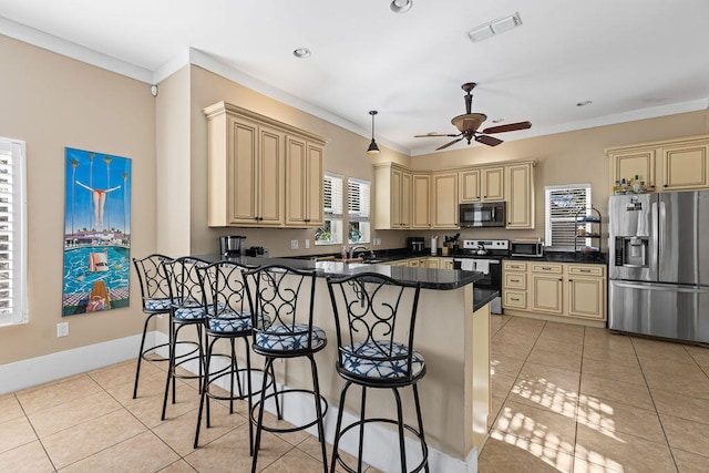 kitchen featuring crown molding, ceiling fan, light tile patterned floors, a kitchen bar, and stainless steel appliances