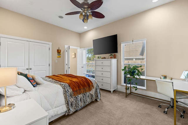 bedroom featuring ceiling fan, a closet, and light colored carpet