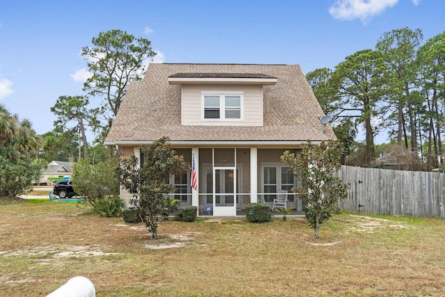 view of front of property with a sunroom and a front yard