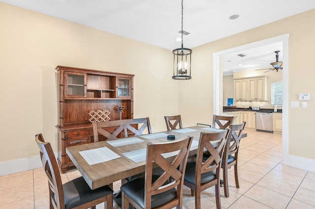 tiled dining space featuring ceiling fan with notable chandelier