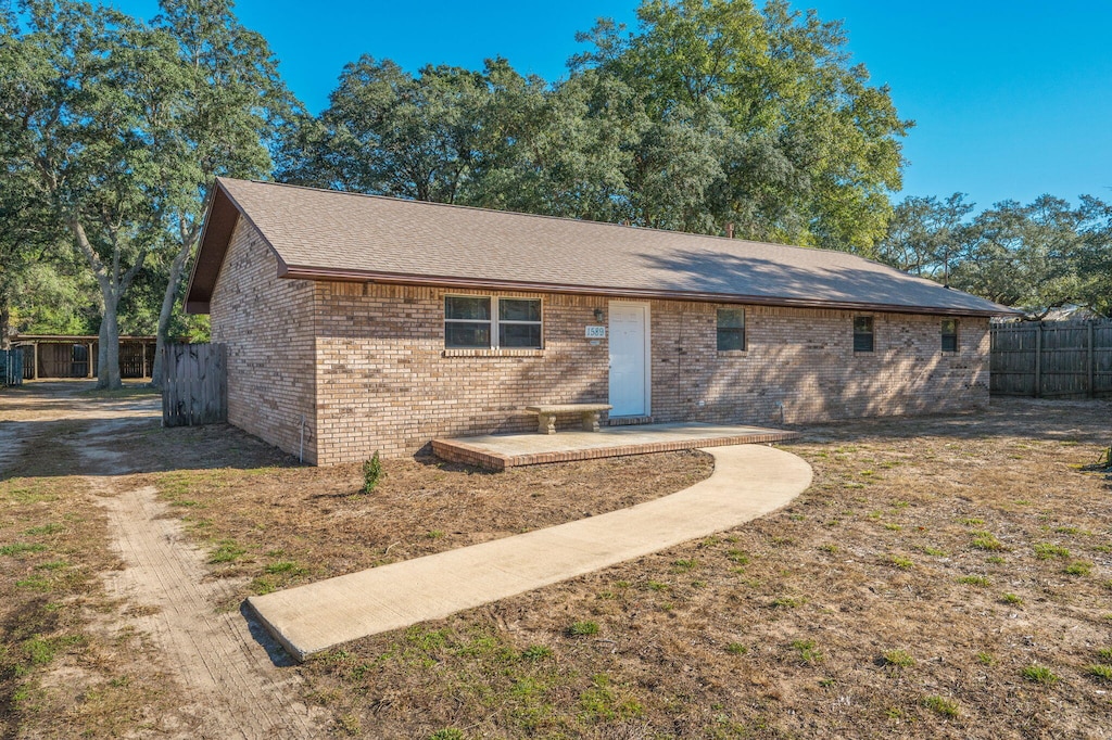 ranch-style house with a patio area and a front lawn