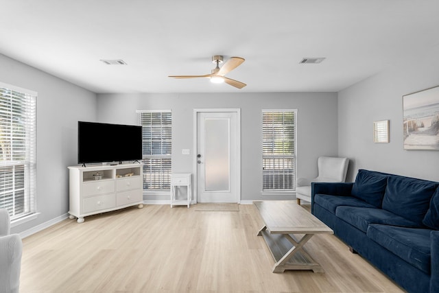 living room with light hardwood / wood-style flooring and ceiling fan