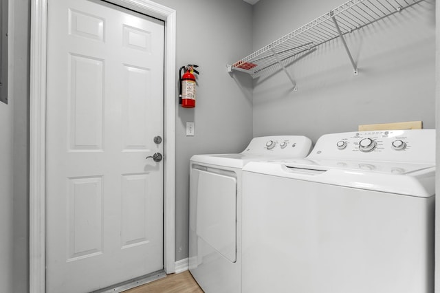 washroom with separate washer and dryer and light hardwood / wood-style flooring