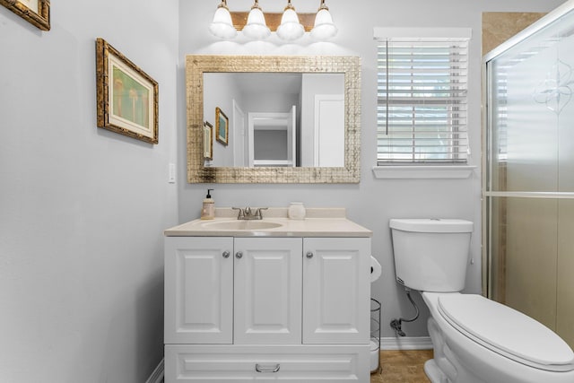 bathroom with vanity, toilet, and a shower with shower door