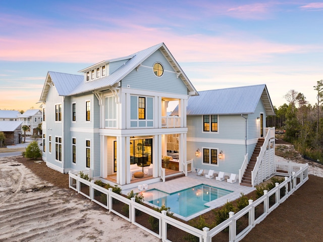 back house at dusk featuring a balcony