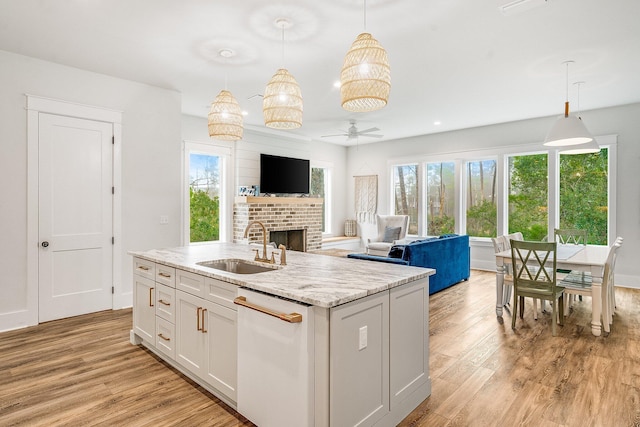 kitchen with ceiling fan, sink, dishwasher, white cabinets, and hanging light fixtures