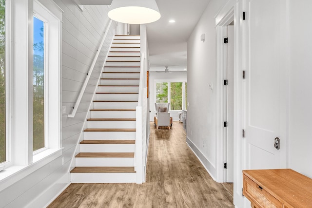 stairs with wood walls and wood-type flooring