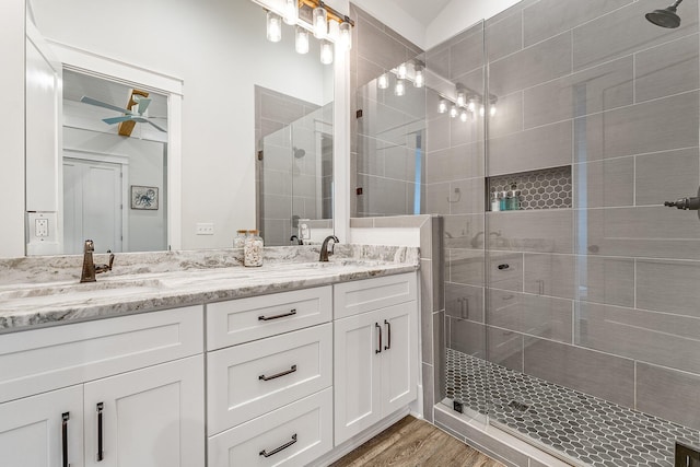 bathroom with ceiling fan, vanity, wood-type flooring, and an enclosed shower