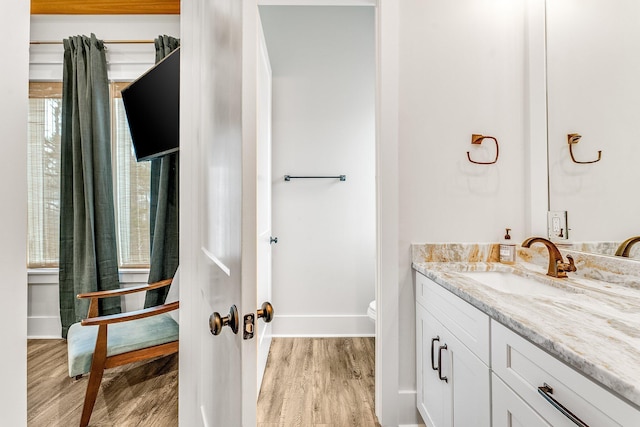 bathroom with hardwood / wood-style flooring, vanity, and toilet