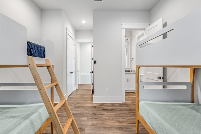 bedroom with hardwood / wood-style floors and ensuite bathroom