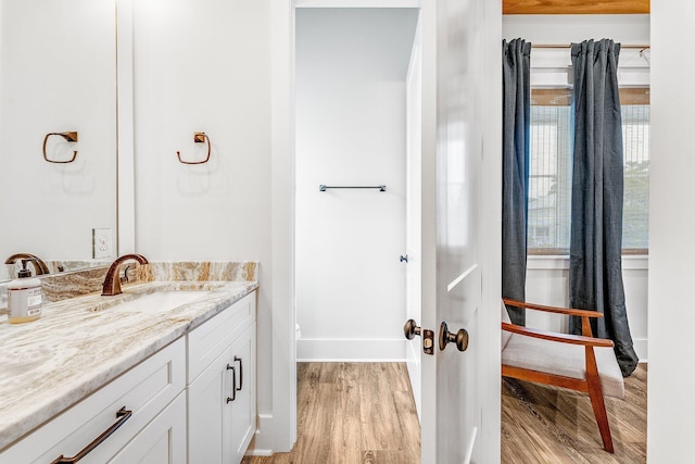 bathroom with wood-type flooring, vanity, and toilet