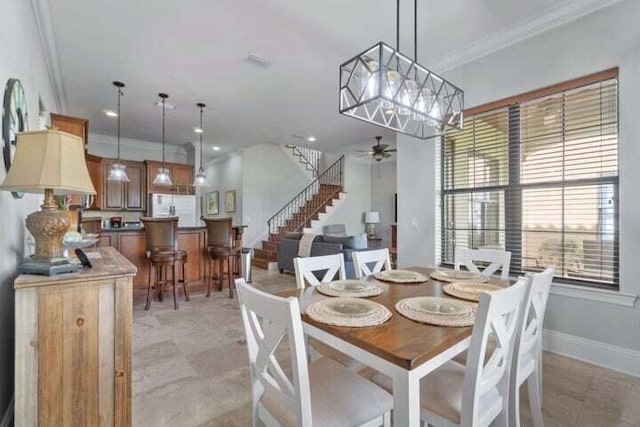 dining area with ceiling fan and crown molding