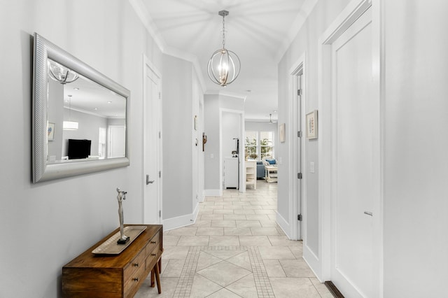 hallway with a chandelier, light tile patterned floors, and crown molding