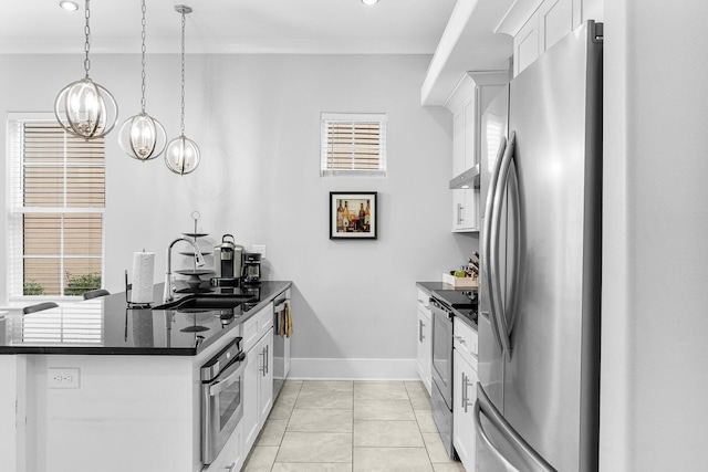 kitchen featuring sink, hanging light fixtures, appliances with stainless steel finishes, a notable chandelier, and white cabinetry