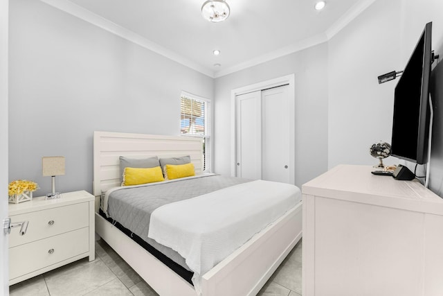 bedroom featuring light tile patterned floors, a closet, and ornamental molding