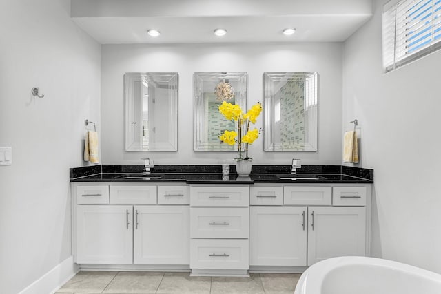 bathroom featuring tile patterned floors, a bathing tub, and vanity