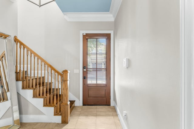 entrance foyer with light tile patterned floors and crown molding