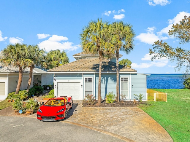 view of front of house with a water view, a garage, and a front lawn