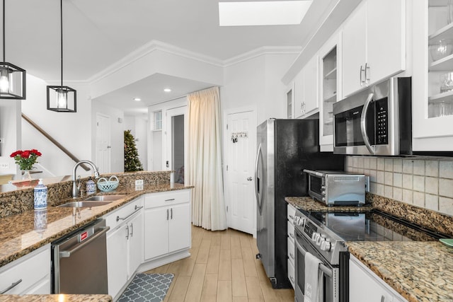 kitchen featuring pendant lighting, white cabinets, stainless steel appliances, and sink