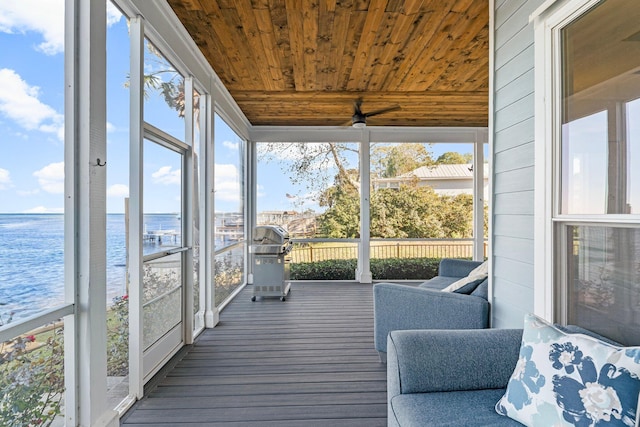 sunroom / solarium with a water view and wood ceiling