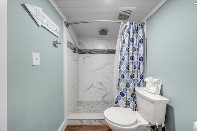 bathroom with toilet and a shower with shower curtain