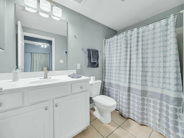 bathroom featuring ceiling fan, tile patterned flooring, a textured ceiling, toilet, and vanity