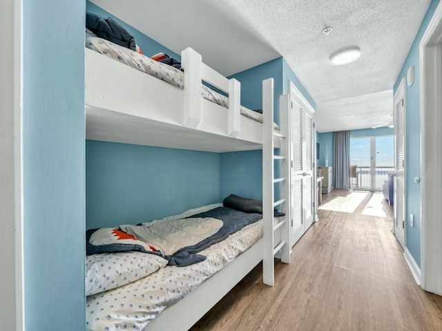 bedroom with a textured ceiling and light hardwood / wood-style flooring