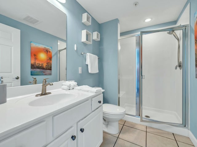 bathroom with tile patterned flooring, vanity, toilet, and a shower with door