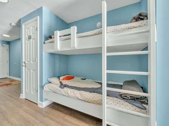 bedroom featuring wood-type flooring and a textured ceiling