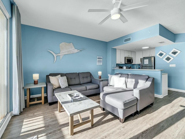 living room featuring ceiling fan and hardwood / wood-style floors