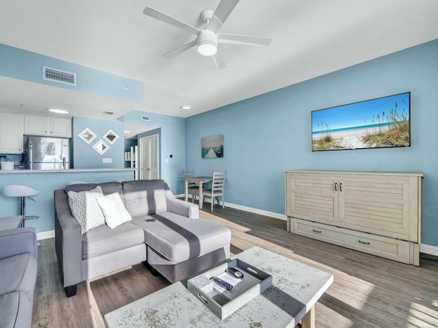 living room with ceiling fan and dark hardwood / wood-style flooring