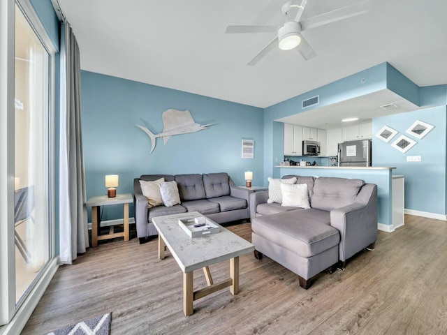 living room with ceiling fan and light wood-type flooring