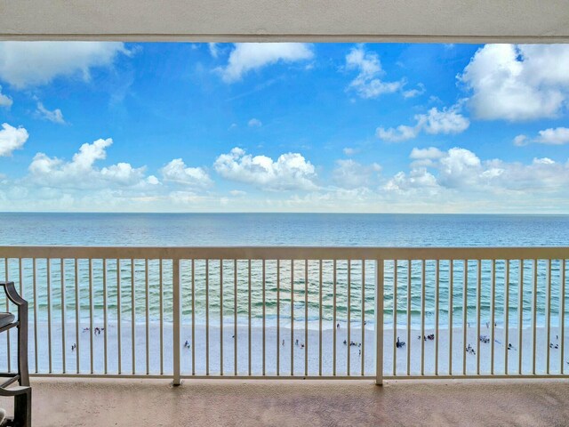 balcony featuring a water view and a beach view