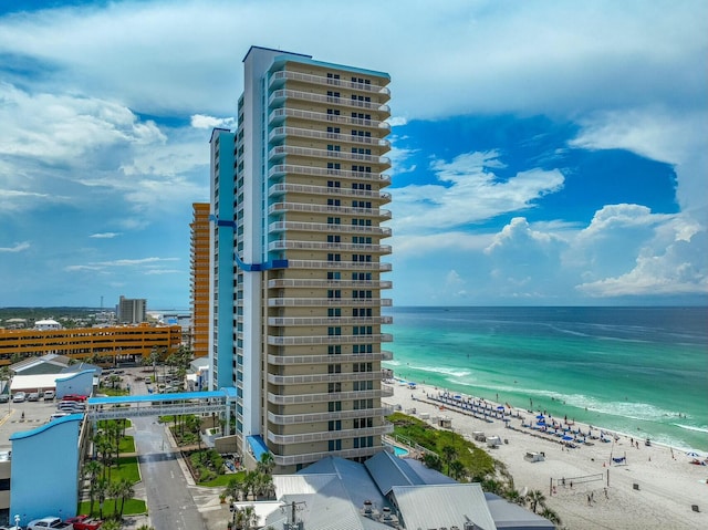 view of building exterior with a beach view and a water view