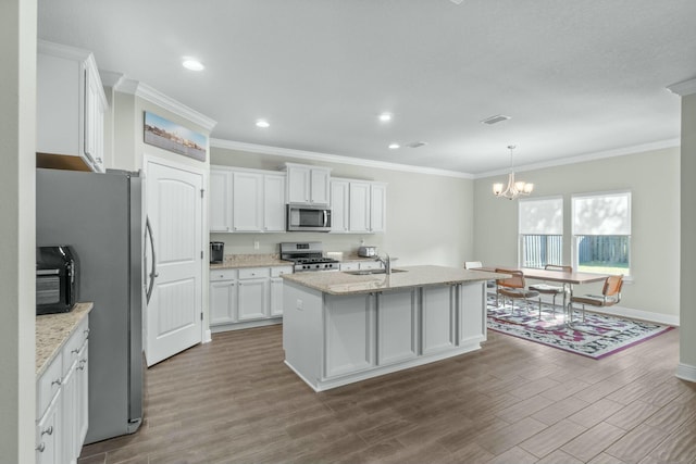 kitchen featuring white cabinets, sink, ornamental molding, an island with sink, and stainless steel appliances