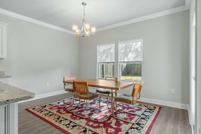 dining space featuring dark hardwood / wood-style flooring, crown molding, and a notable chandelier