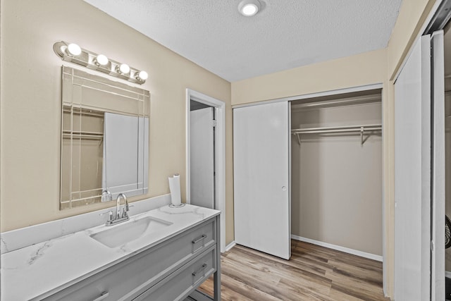 bathroom featuring hardwood / wood-style flooring, vanity, and a textured ceiling