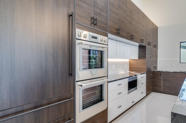 kitchen with white cabinets, refrigerator, and stainless steel double oven