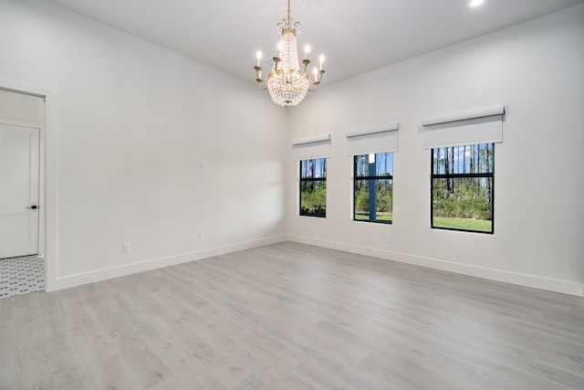 unfurnished room with a chandelier, light hardwood / wood-style flooring, and plenty of natural light