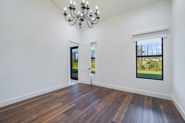 unfurnished room featuring a chandelier, dark hardwood / wood-style flooring, and high vaulted ceiling