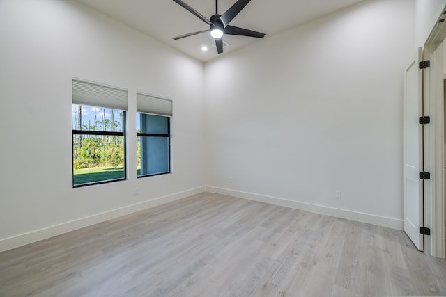 empty room with ceiling fan and light hardwood / wood-style floors