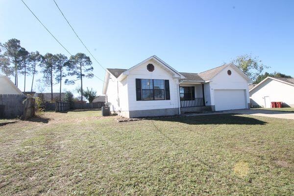 single story home featuring a garage, concrete driveway, a front yard, and fence