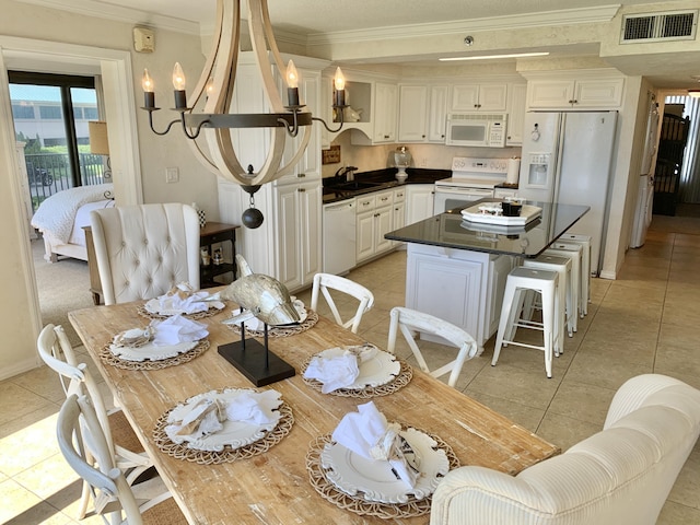 tiled dining space with crown molding, sink, and an inviting chandelier